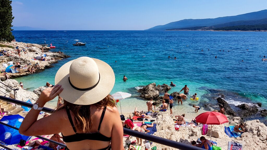 Badegäste an einem Strand an der Adriaküste in Kroatien im Sommer