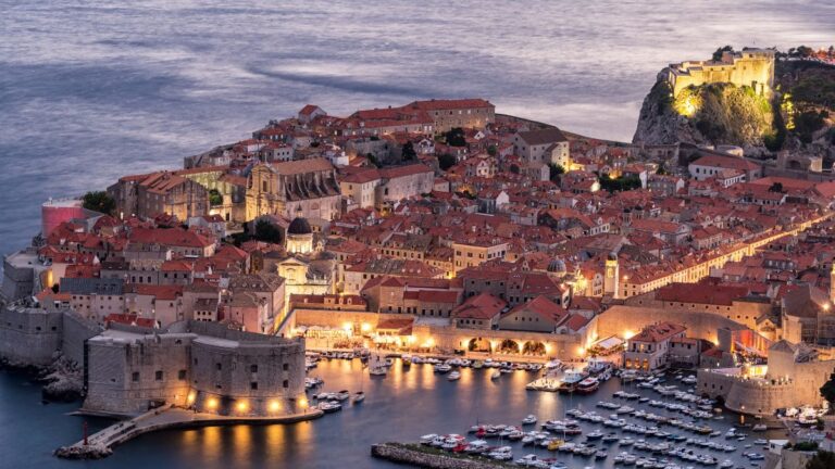 Dubrovnik Altstadt am Abend mit beleuchtetem Hafen und Blick auf die Adria