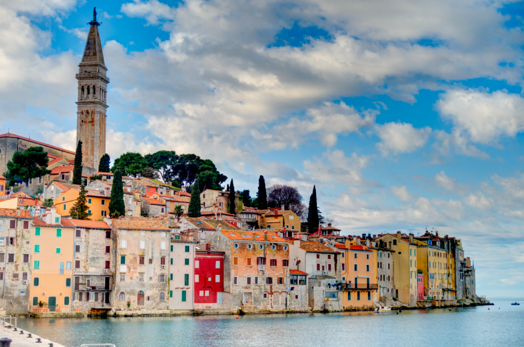 Pastellfarbene Häuser der Altstadt von Rovinj in Kroatien direkt am Wasser, Blick entlang der Küste