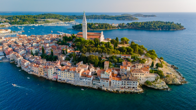 Altstadt von Rovinj in Kroatien mit pastellfarbenen Häusern direkt am Meer, Blick von oben auf die Küste