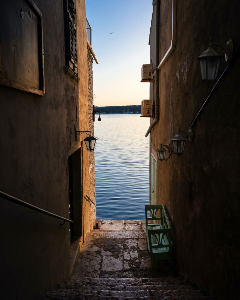 Schmale Gasse in der Altstadt von Rovinj in Kroatien mit Blick auf das Meer.