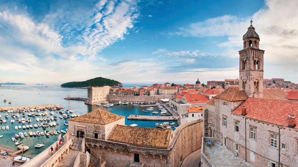 Blick über die Altstadt von Dubrovnik mit Stadtmauer, Hafen, roten Dächern und der Adria im Hintergrund