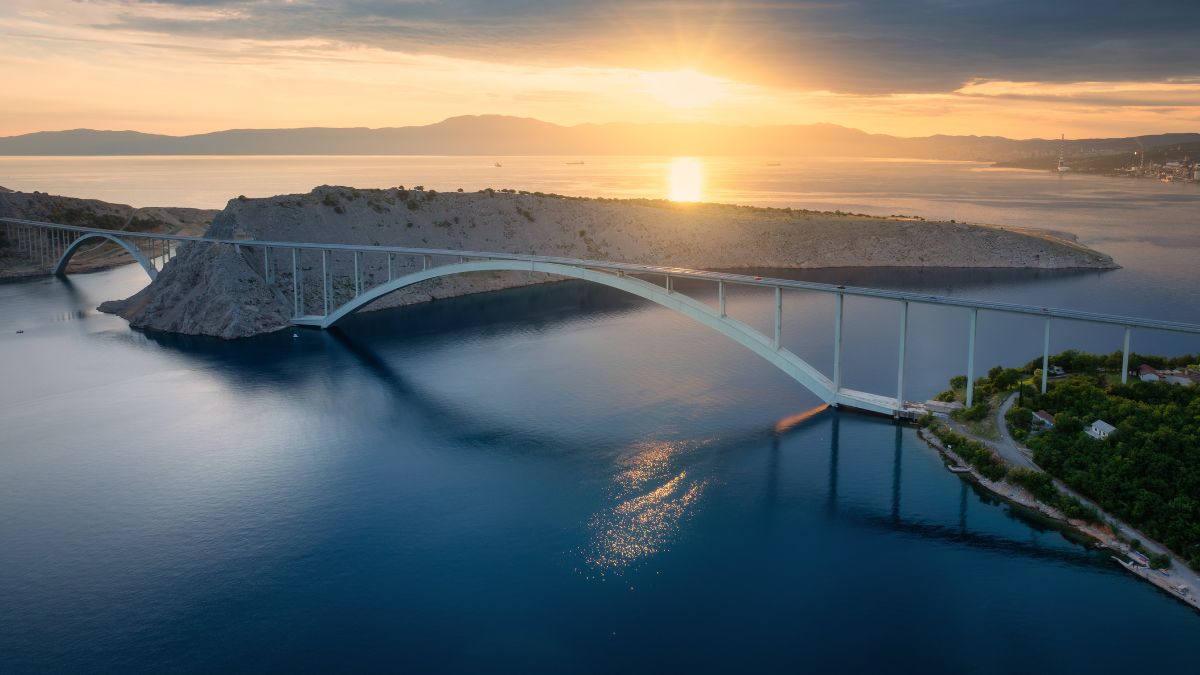 Krk-Brücke bei Sonnenuntergang mit Blick auf Meer und Küstenlandschaft in Kroatien